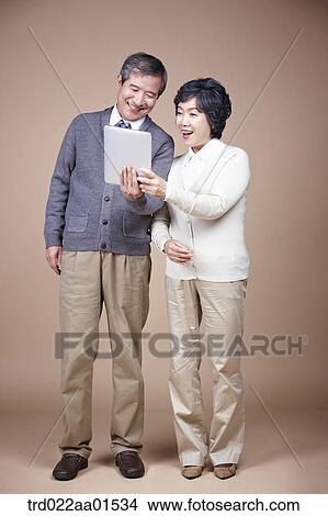 A old man and old woman looking at tablet PC View Large Photo Image Picture - A old man and old woman looking at tablet PC. Fotosearch