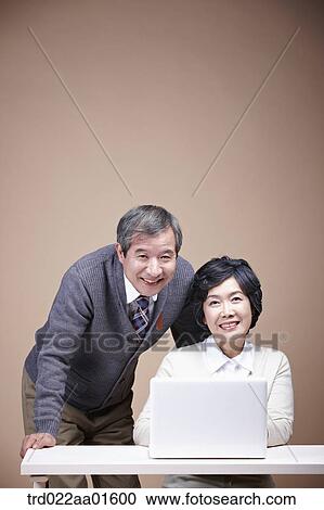 A smiling old man and old woman with laptop View Large Photo Image Stock Image - A smiling old man and old woman with laptop. Fotosearch