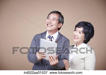 A smiling old man and old woman with tablet PC View Large Photo Image Stock Photo - A smiling old man and old woman with tablet PC. Fotosearch