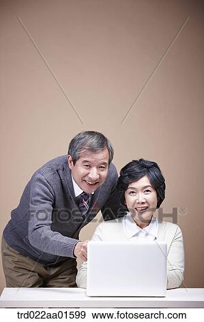 A smiling old man and old woman with laptop View Large Photo Image Stock Photo - A smiling old man and old woman with laptop. Fotosearch