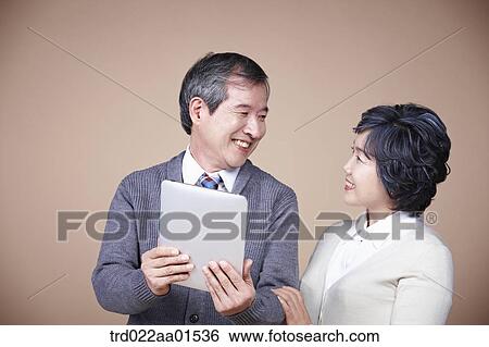 A smiling old man and old woman with tablet PC View Large Photo Image Stock Photograph - A smiling old man and old woman with tablet PC. Fotosearch