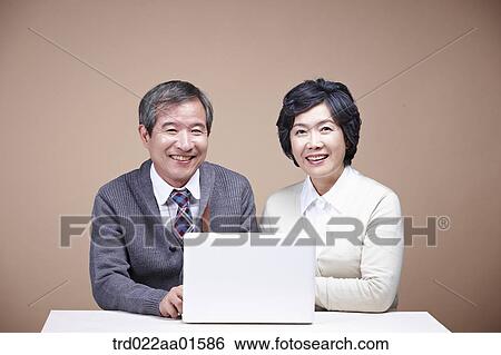 A smiling old man and old woman with laptop View Large Photo Image Stock Photograph - A smiling old man and old woman with laptop. Fotosearch