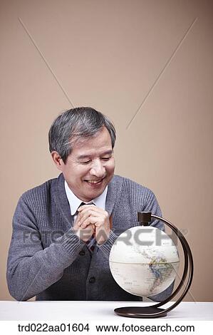 A smiling old man looking at the globe View Large Photo Image Picture - A smiling old man looking at the globe. Fotosearch