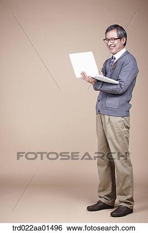 Stock Photograph - A smiling old man with laptop. Fotosearch