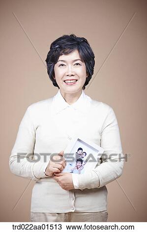 A smiling old woman with family photograph View Large Photo Image Stock Image - A smiling old woman with family photograph. Fotosearch