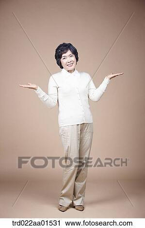 A standing old woman with her hands open View Large Photo Image Stock Image - A standing old woman with her hands open. Fotosearch
