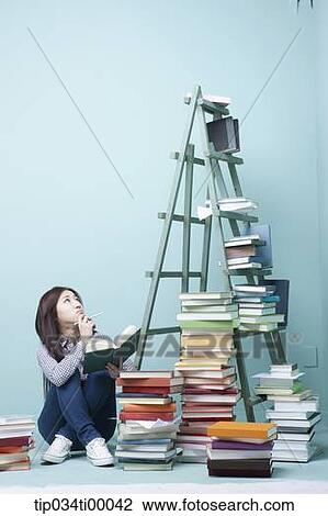 A studying woman by the piled books and ladder View Large Photo Image Stock Image - A studying woman by the piled books and ladder. Fotosearch