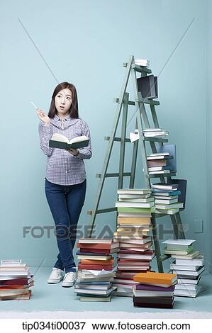 A studying woman by the piled books and ladder View Large Photo Image Stock Photo - A studying woman by the piled books and ladder. Fotosearch