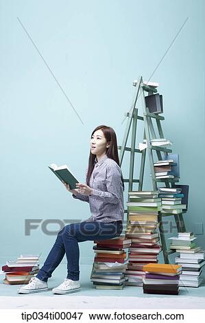 A studying woman on the piled books View Large Photo Image Stock Photo - A studying woman on the piled books. Fotosearch