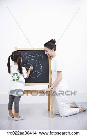 Picture - A woman and girl painting green globe on blackboard . Fotosearch