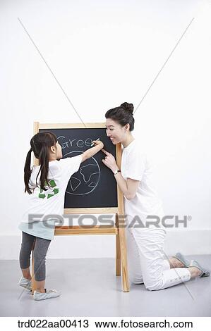 A woman and girl painting green globe on blackboard View Large Photo Image Stock Image - A woman and girl painting green globe on blackboard . Fotosearch