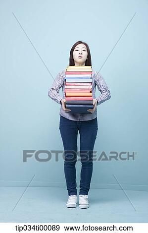 A woman carrying the pile of books View Large Photo Image Stock Photo - A woman carrying the pile of books. Fotosearch