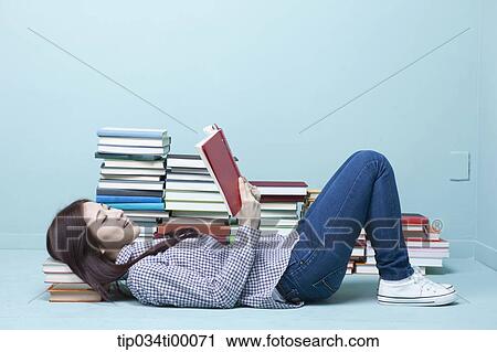 A woman reading a book on the floor View Large Photo Image Stock Image - A woman reading a book on the floor. Fotosearch