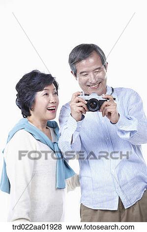 An old couple photographing with camera View Large Photo Image Stock Photo - An old couple photographing with camera. Fotosearch