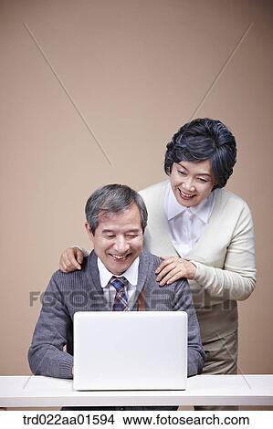 An old man and old woman looking at laptop View Large Photo Image Picture - An old man and old woman looking at laptop . Fotosearch
