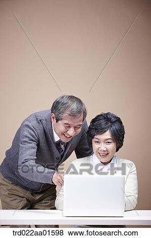 An old man and old woman looking at laptop View Large Photo Image Stock Photo - An old man and old woman looking at laptop . Fotosearch