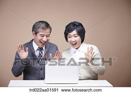 Stock Image - An old man and old woman surprised at laptop monitor. Fotosearch