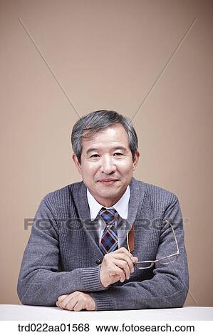An old man holding the glasses View Large Photo Image Stock Photo - An old man holding the glasses. Fotosearch