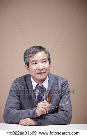 Stock Photo - An old man holding the glasses. Fotosearch