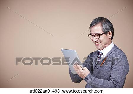 An old man looking at tablet PC View Large Photo Image Stock Image - An old man looking at tablet PC. Fotosearch