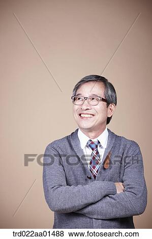 An old man looking at the right side with his arms folded View Large Photo Image Stock Photo - An old man looking at the right side with his arms folded. Fotosearch