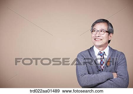 An old man looking at the right side with his arms folded View Large Photo Image Stock Photo - An old man looking at the right side with his arms folded. Fotosearch