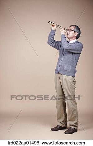 Stock Photo - An old man looking through telescope. Fotosearch