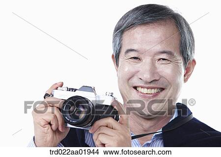 Picture - An old man photographing with camera. Fotosearch