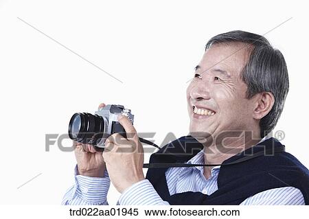 An old man photographing with camera View Large Photo Image Stock Photography - An old man photographing with camera. Fotosearch