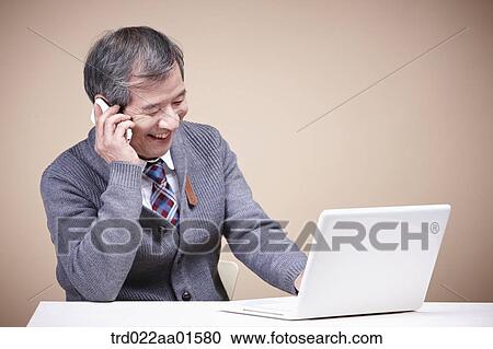 An old man talking on the phone with the laptop around View Large Photo Image Stock Image - An old man talking on the phone with the laptop around. Fotosearch
