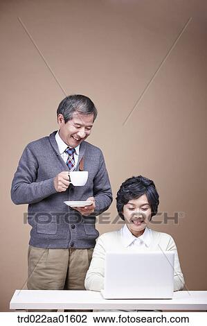 An old man with a cup of coffee and old woman with laptop View Large Photo Image Stock Image - An old man with a cup of coffee and old woman with laptop. Fotosearch
