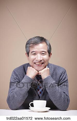 Stock Image - An old man with a cup of coffee. Fotosearch