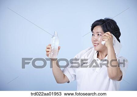 Stock Image - An old woman drinking a bottle of water. Fotosearch