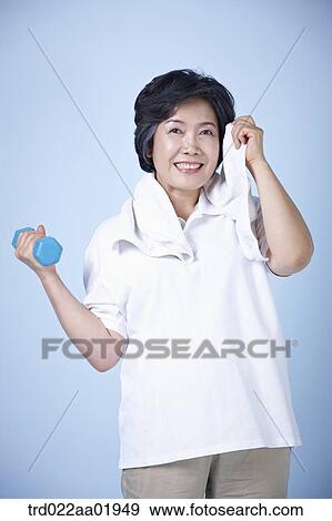 Stock Photo - An old woman exercising with dumbbell . Fotosearch