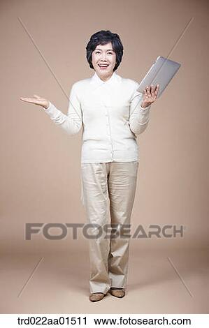 An old woman holding tablet PC with her hand open View Large Photo Image Stock Image - An old woman holding tablet PC with her hand open. Fotosearch