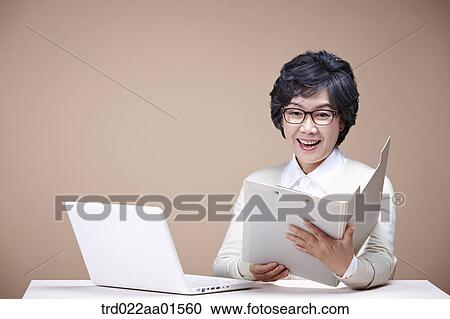 An old woman looking at document with laptop around View Large Photo Image Stock Image - An old woman looking at document with laptop around. Fotosearch