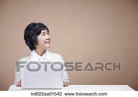 An old woman looking at left side with laptop View Large Photo Image Stock Image - An old woman looking at left side with laptop. Fotosearch