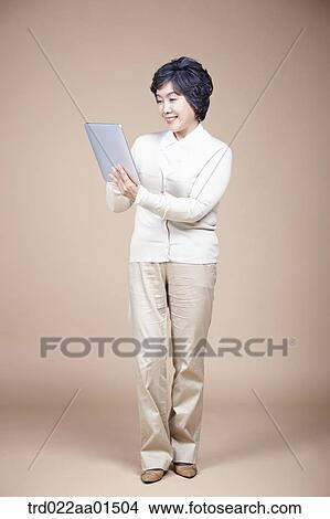 An old woman looking at tablet PC View Large Photo Image Picture - An old woman looking at tablet PC. Fotosearch