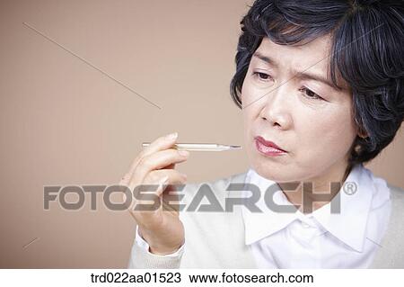 An old woman looking at thermometer seriously View Large Photo Image Stock Image - An old woman looking at thermometer seriously . Fotosearch