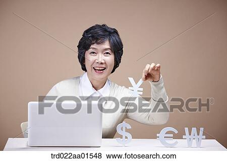 An old woman picking up foreign currency with laptop around View Large Photo Image Stock Photo - An old woman picking up foreign currency with laptop around. Fotosearch