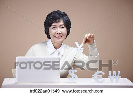 An old woman picking up foreign currency with laptop around View Large Photo Image Stock Photo - An old woman picking up foreign currency with laptop around. Fotosearch