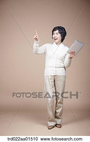 An old woman pointing her finger with tablet PC View Large Photo Image Stock Image - An old woman pointing her finger with tablet PC. Fotosearch