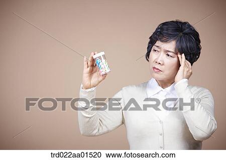An old woman suffering from headache with medicine View Large Photo Image Stock Image - An old woman suffering from headache with medicine. Fotosearch