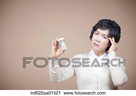 An old woman suffering from headache with medicine View Large Photo Image Stock Image - An old woman suffering from headache with medicine. Fotosearch