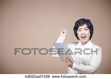 An old woman thinking of idea with tablet PC View Large Photo Image Stock Photo - An old woman thinking of idea with tablet PC. Fotosearch