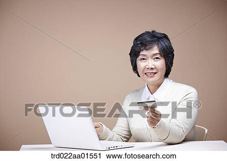 An old woman with credit card and laptop View Large Photo Image Stock Image - An old woman with credit card and laptop. Fotosearch