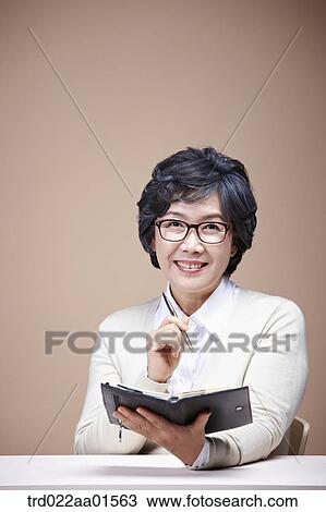 Stock Image - An old woman with planner. Fotosearch
