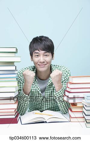 Cheerful man while studying at the desk View Large Photo Image Stock Image - Cheerful man while studying at the desk. Fotosearch