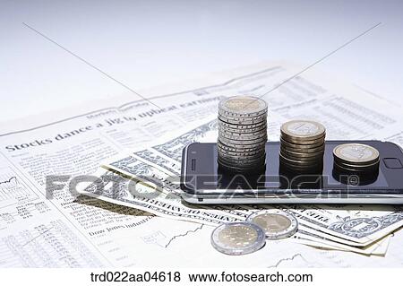 Stock Photo - Smartphone and money on the newspaper. Fotosearch