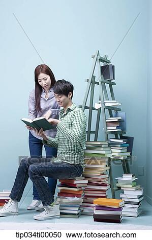 Studying man and woman by the piled books View Large Photo Image Stock Image - Studying man and woman by the piled books. Fotosearch